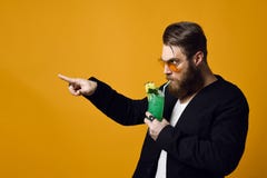 Портрет харизматического бородатого человека в солнечных очках с коктейлем в его руках стоковые изображения rf Портрет харизматического бородатого человека в солнечных очках с коктейлем в его руках стоковые изображения rf