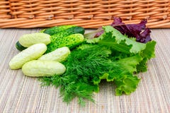 Пестротканый салат лист, огурцы, укроп на плетеной салфетке подготовленной для отрезать салат стоковая фотография rf Пестротканый салат лист, огурцы, укроп на плетеной салфетке подготовленной для отрезать салат стоковая фотография rf