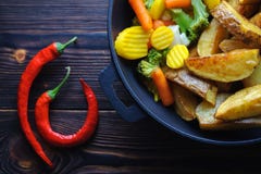 Печеные картофели с овощами в перце сковороды и chili стоковое изображение Печеные картофели с овощами в перце сковороды и chili стоковое изображение