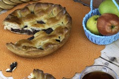 Пирог, кусок яблочного пирога с вишней и грецкими орехами, чашка чаю, яблоки в корзине, грецкие орехи и печенья на таблице стоковые изображения rf Пирог, кусок яблочного пирога с вишней и грецкими орехами, чашка чаю, яблоки в корзине, грецкие орехи и печенья на таблице стоковые изображения rf