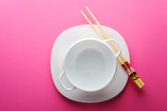 Плита китайских ручек белая на розовой предпосылке стоковые изображения Плита китайских ручек белая на розовой предпосылке стоковые изображения