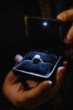 Предложение действительности: Человек держит загоренное обручальное кольцо - голубое кольцо невесты с большим самоцветом стоковые изображения rf Предложение действительности: Человек держит загоренное обручальное кольцо - голубое кольцо невесты с большим самоцветом стоковые изображения rf