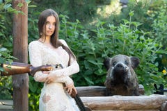 Прекрасная девушка в белом платье представляя с охотясь винтовкой стоковое фото Прекрасная девушка в белом платье представляя с охотясь винтовкой стоковое фото