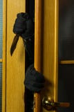 Преступник получает в квартиру Руки человека в черных перчатках и ноже стоковые изображения Преступник получает в квартиру Руки человека в черных перчатках и ноже стоковые изображения