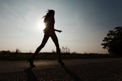 Привлекательная женщина с длинным - силуэт против света солнца стоковое фото rf Привлекательная женщина с длинным - силуэт против света солнца стоковое фото rf