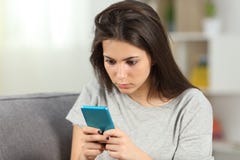Пристрастившийся предназначенное для подростков проверяя умное содержание телефона дома стоковое фото rf Пристрастившийся предназначенное для подростков проверяя умное содержание телефона дома стоковое фото rf