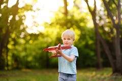 Сute little boy playing with toy airplane in the sunny park stock photo Сute little boy playing with toy airplane in the sunny park stock photo