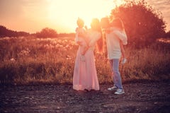 Семья с детьми на заходе солнца стоковые фотографии rf Семья с детьми на заходе солнца стоковые фотографии rf