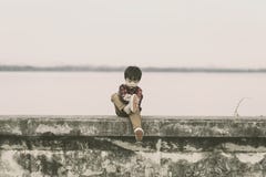 Сиротливые дети принимают ботинки и он сидит на том основании стоковая фотография Сиротливые дети принимают ботинки и он сидит на том основании стоковая фотография