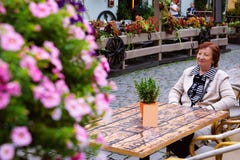 Старшая женщина на кафе улицы террасы в старом городке Риге стоковые фото Старшая женщина на кафе улицы террасы в старом городке Риге стоковые фото