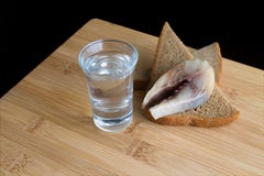 Стекло с водкой и закуской со шпротиной и хлебом Черная предпосылка стоковое фото rf Стекло с водкой и закуской со шпротиной и хлебом Черная предпосылка стоковое фото rf