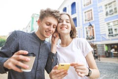 Счастливые пары слушая музыку в одном наушнике 2 Счастливый молодой человек со стеклом кофе в его руках стоковые фото Счастливые пары слушая музыку в одном наушнике 2 Счастливый молодой человек со стеклом кофе в его руках стоковые фото
