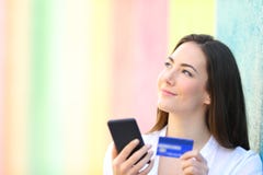 Счастливый онлайн покупатель думая смотрящ сторону стоковое изображение rf Счастливый онлайн покупатель думая смотрящ сторону стоковое изображение rf