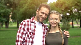 Счастливый отец обнимая его красивую молодую дочь, усмехаясь в камеру, семья стоковые фотографии rf Счастливый отец обнимая его красивую молодую дочь, усмехаясь в камеру, семья стоковые фотографии rf