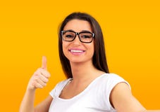 Счастливый красивый показывать женщины большие пальцы руки вверх по жесту пока принимающ selfie стоковое фото rf Счастливый красивый показывать женщины большие пальцы руки вверх по жесту пока принимающ selfie стоковое фото rf