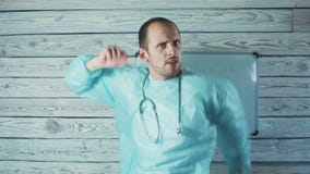 Счастливый мужской кавказский доктор со светлыми танцами бороды в его медицинском офисе акции видеоматериалы Счастливый мужской кавказский доктор со светлыми танцами бороды в его медицинском офисе акции видеоматериалы