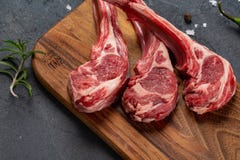 Сырое мясо на косточке с оливковым маслом, свежими травами и специями, черной предпосылкой для варить с космосом экземпляра стоковые изображения rf Сырое мясо на косточке с оливковым маслом, свежими травами и специями, черной предпосылкой для варить с космосом экземпляра стоковые изображения rf