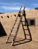 Юго-западная лестница полагаясь против стены самана в Пуэбло Taos стоковая фотография Юго-западная лестница полагаясь против стены самана в Пуэбло Taos стоковая фотография