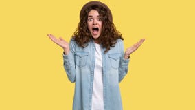 Удивленный молодой брюнет с вьющиеся волосы изумлял выражение на ее стороне, стоковое изображение Удивленный молодой брюнет с вьющиеся волосы изумлял выражение на ее стороне, стоковое изображение
