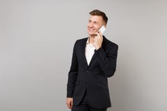 Усмехаясь бизнесмен в классическом костюме смотря в сторону говорить на мобильном телефоне проводя приятный разговор изолированны стоковое фото rf Усмехаясь бизнесмен в классическом костюме смотря в сторону говорить на мобильном телефоне проводя приятный разговор изолированны стоковое фото rf