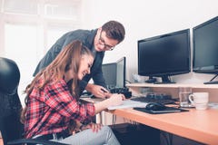 Усмехаясь молодые коллеги работая с документами в офисе стоковое фото Усмехаясь молодые коллеги работая с документами в офисе стоковое фото