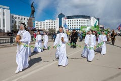 Участники демонстрации парада - Yakut девушки в национальных костюмах держат Sakha Choron стоковые изображения Участники демонстрации парада - Yakut девушки в национальных костюмах держат Sakha Choron стоковые изображения