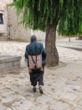 Тибетский человек с оплетками в традиционных одеждах идя около сывороток монастыря, Лхасы, Тибета, Китая стоковая фотография Тибетский человек с оплетками в традиционных одеждах идя около сывороток монастыря, Лхасы, Тибета, Китая стоковая фотография