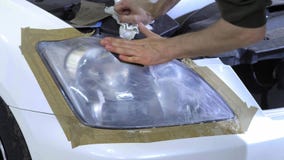 Фара полируя, обработка светов автомобиля Работник обслуживания автомобиля полирует фару пассажирского автомобиля сток-видео Фара полируя, обработка светов автомобиля Работник обслуживания автомобиля полирует фару пассажирского автомобиля сток-видео