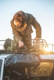 Человек принимая багаж от крыши фургона стоковые фото Человек принимая багаж от крыши фургона стоковые фото