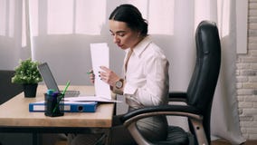 Работы молодой женщины с документами в офисе Работы молодой женщины с документами в офисе
