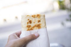 Рука держа обруч, хлеб, piadina, против белой предпосылки нерезкости стоковое фото rf Рука держа обруч, хлеб, piadina, против белой предпосылки нерезкости стоковое фото rf