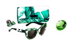 Óculos de sol no quadro branco-verde plástico em combinação com uma tampa em um fundo branco imagens de stock Óculos de sol no quadro branco-verde plástico em combinação com uma tampa em um fundo branco imagens de stock
