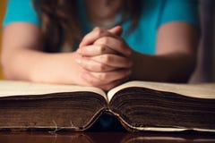 Öffnen Sie Bibel mit betendem Mädchen lizenzfreie stockbilder Öffnen Sie Bibel mit betendem Mädchen lizenzfreie stockbilder