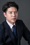 Östligt asiatiskt foto för stående för affärsmanskyttestudio royaltyfria bilder Östligt asiatiskt foto för stående för affärsmanskyttestudio royaltyfria bilder