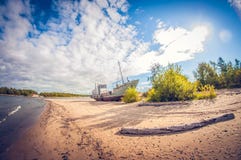Övergett fartyg på den sandiga kusten av en sjö på en solig dag lins för distorsionsperspektivfisheye arkivfoton Övergett fartyg på den sandiga kusten av en sjö på en solig dag lins för distorsionsperspektivfisheye arkivfoton