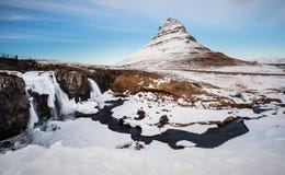 Övervintra landskapet, vattenfall med berget Kirkjufell i Island royaltyfri bild Övervintra landskapet, vattenfall med berget Kirkjufell i Island royaltyfri bild
