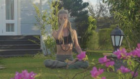 Övning för Pranayama yogaandedräkt av en ung kvinna i trädgården av hennes hus arkivfilmer Övning för Pranayama yogaandedräkt av en ung kvinna i trädgården av hennes hus arkivfilmer
