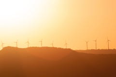 Última puesta del sol brillante con los molinoes de viento en el horizonte fotos de archivo libres de regalías Última puesta del sol brillante con los molinoes de viento en el horizonte fotos de archivo libres de regalías