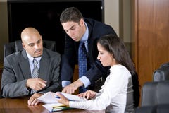 Überprüfungreport mit drei hispanischer Büroangestellten stockbild Überprüfungreport mit drei hispanischer Büroangestellten stockbild