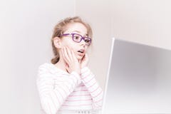 Überraschtes und entsetztes Kindermädchenkind unter Verwendung der Laptop-Computers lizenzfreies stockbild Überraschtes und entsetztes Kindermädchenkind unter Verwendung der Laptop-Computers lizenzfreies stockbild