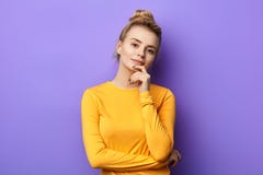 Überzeugtes atractive Mädchen in der gelben Strickjacke, welche die Kamera betrachtet stockfoto Überzeugtes atractive Mädchen in der gelben Strickjacke, welche die Kamera betrachtet stockfoto