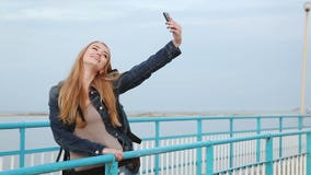 Ładna dziewczyna robi selfies stoi obok rzeki zdjęcie wideo Ładna dziewczyna robi selfies stoi obok rzeki zdjęcie wideo