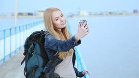 Ładna dziewczyna robi selfies stoi obok rzeki zbiory wideo Ładna dziewczyna robi selfies stoi obok rzeki zbiory wideo