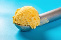 Łyżka z mangową smaku lody piłką na błękicie zamkniętym w górę zdjęcie royalty free Łyżka z mangową smaku lody piłką na błękicie zamkniętym w górę zdjęcie royalty free