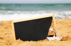 Łódź i chalkboard, na dennym piasku i oceanu horyzoncie Fotografia Royalty Free