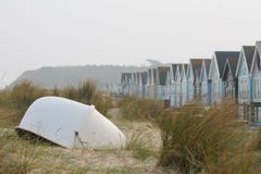 Łódź z plażowymi budami przy Mudeford, Dorset, UK fotografia stock Łódź z plażowymi budami przy Mudeford, Dorset, UK fotografia stock