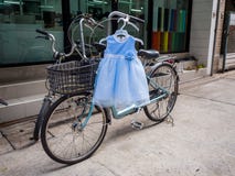 Śliczna dziecko bielu i błękita suknia wiesza na bicyklu zdjęcia royalty free Śliczna dziecko bielu i błękita suknia wiesza na bicyklu zdjęcia royalty free