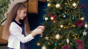 Śliczna dziewczyna dekoruje xmas drzewa z kolorowym bauble zbiory Śliczna dziewczyna dekoruje xmas drzewa z kolorowym bauble zbiory