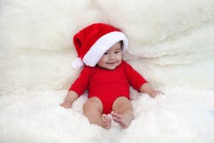Śliczni pięć miesięcy azjatykciego dziecka ono uśmiecha się z Santa kapeluszem na jaskrawym miękkim dywanie Zdjęcia Stock Śliczni pięć miesięcy azjatykciego dziecka ono uśmiecha się z Santa kapeluszem na jaskrawym miękkim dywanie Zdjęcia Stock