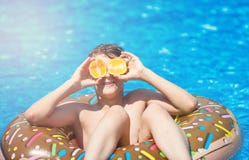 Śliczni sporty chłopiec pływania w basenie z pączkiem i dzwonią zabawę, uśmiechy, chwyt pomarańcze być na wakacjach z dzieciakami obrazy royalty free Śliczni sporty chłopiec pływania w basenie z pączkiem i dzwonią zabawę, uśmiechy, chwyt pomarańcze być na wakacjach z dzieciakami obrazy royalty free